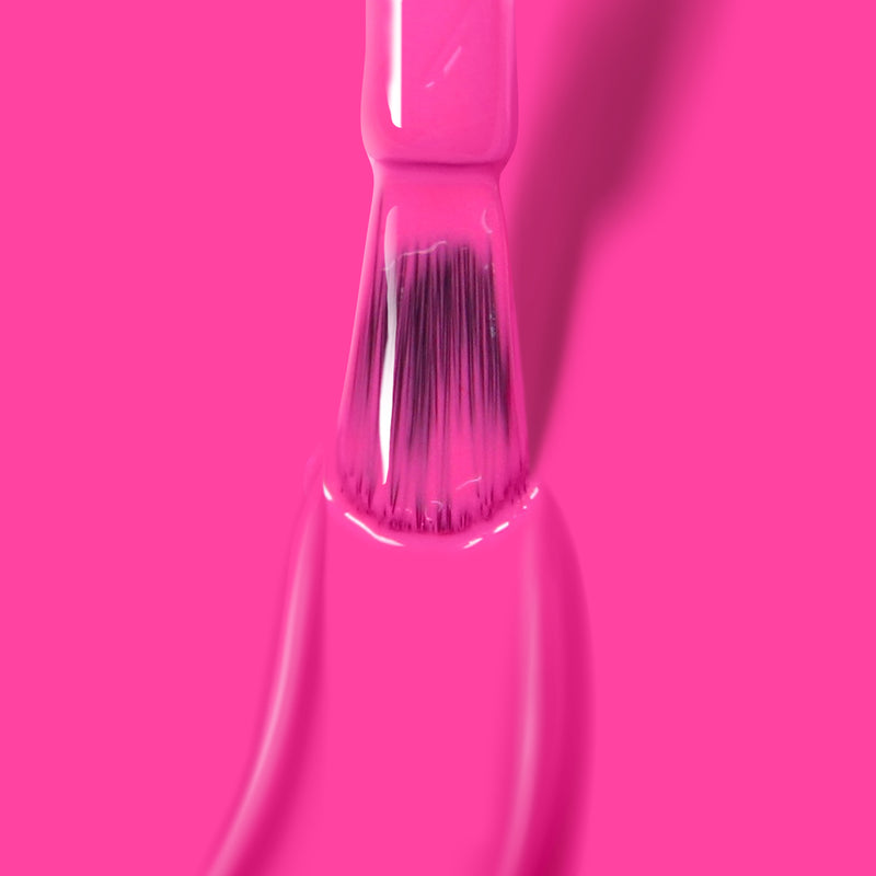 A close-up of a paintbrush applying LONDONTOWN's Berry Punch paint on a surface.