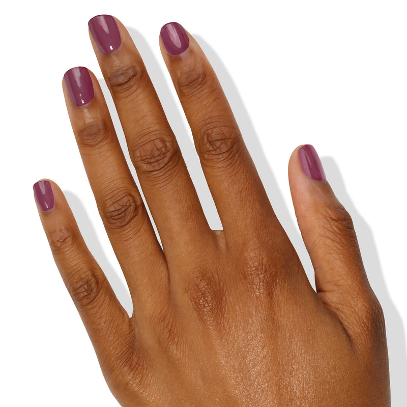 A hand with a medium-dark skin tone, adorned with LONDONTOWN's Best Year Ever berry-colored nail polish on all five fingers, is shown against a white background.