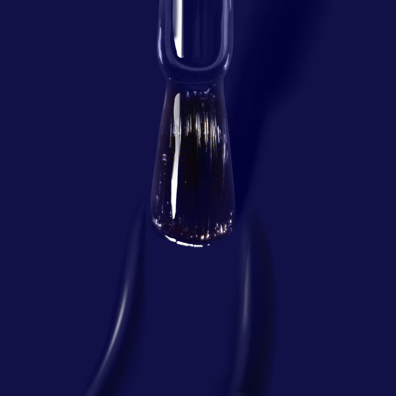 A close-up view of a nail polish brush coated in Buckingham Blue, a rich navy hue from LONDONTOWN, formulated to be vegan and cruelty-free.