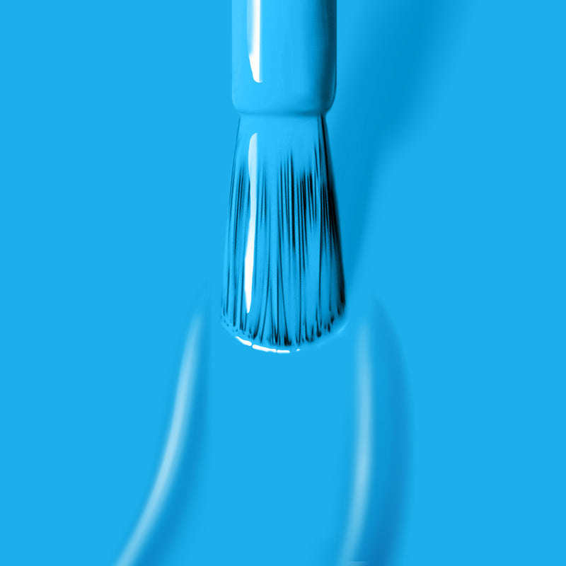 Close-up of a paintbrush covered in LONDONTOWN's Cabana Boy neon blue paint, with brush strokes visible against a vibrant neon blue background.