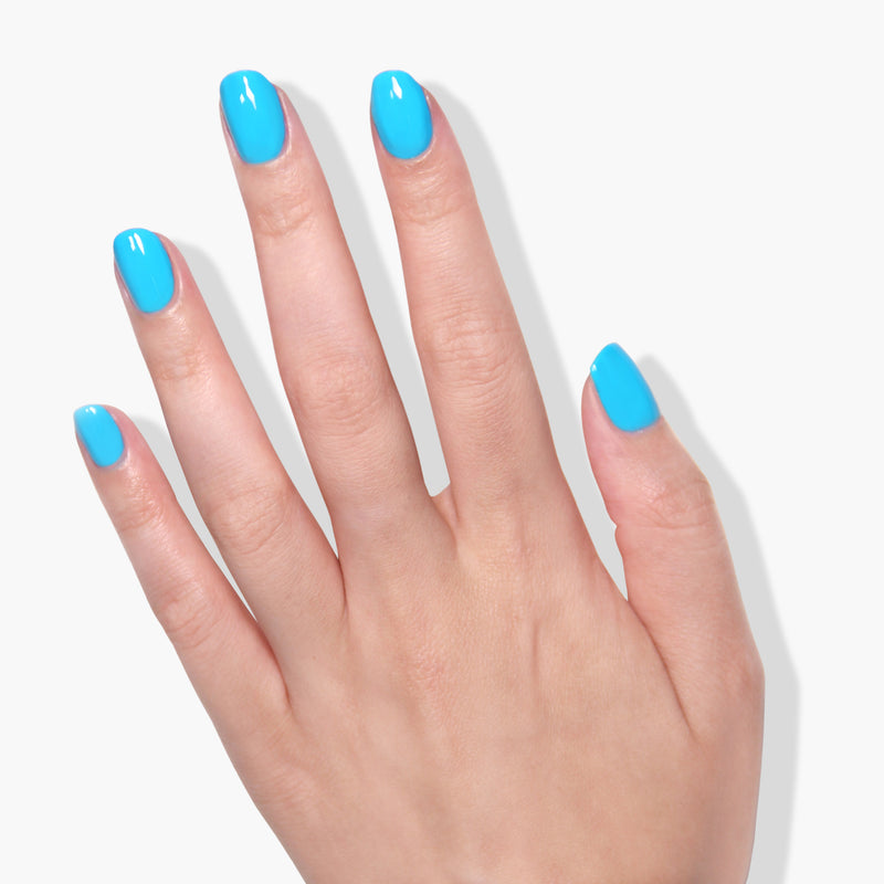 A left hand with neatly manicured nails painted in the vibrant neon blue color of LONDONTOWN's Cabana Boy, set against a white background, showcasing extended wear & shine.