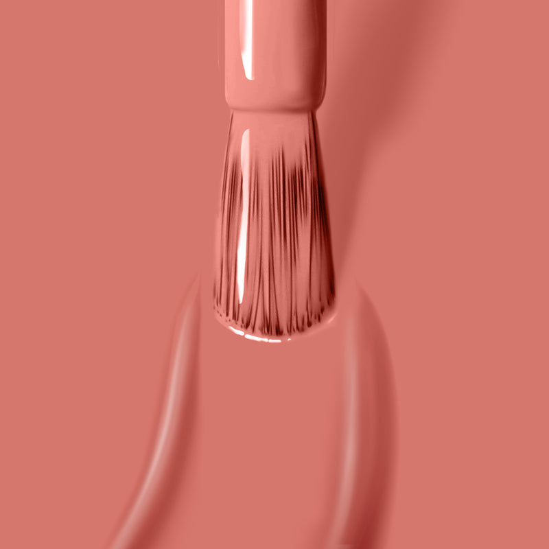 Close-up of a brush applying LONDONTOWN's Cactus Coral nail polish, with the bristles spreading the lush, dusty coral color evenly.