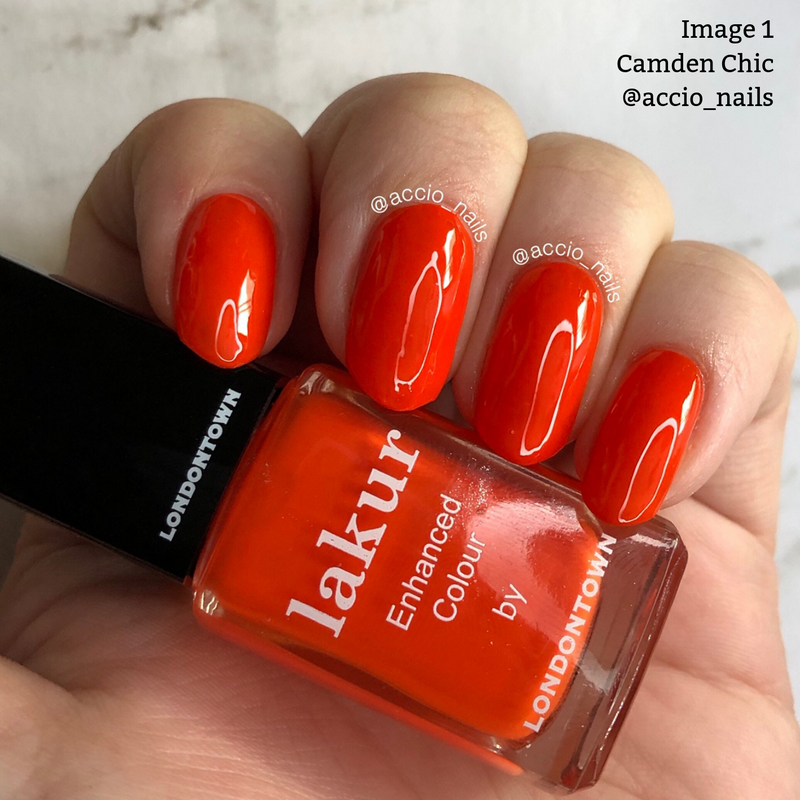 A hand with citrusy orange crème-painted nails holds a bottle of LONDONTOWN Camden Chic nail polish, boasting a vegan cruelty-free formula. The Instagram handle @accio_nails is written on the bottle.