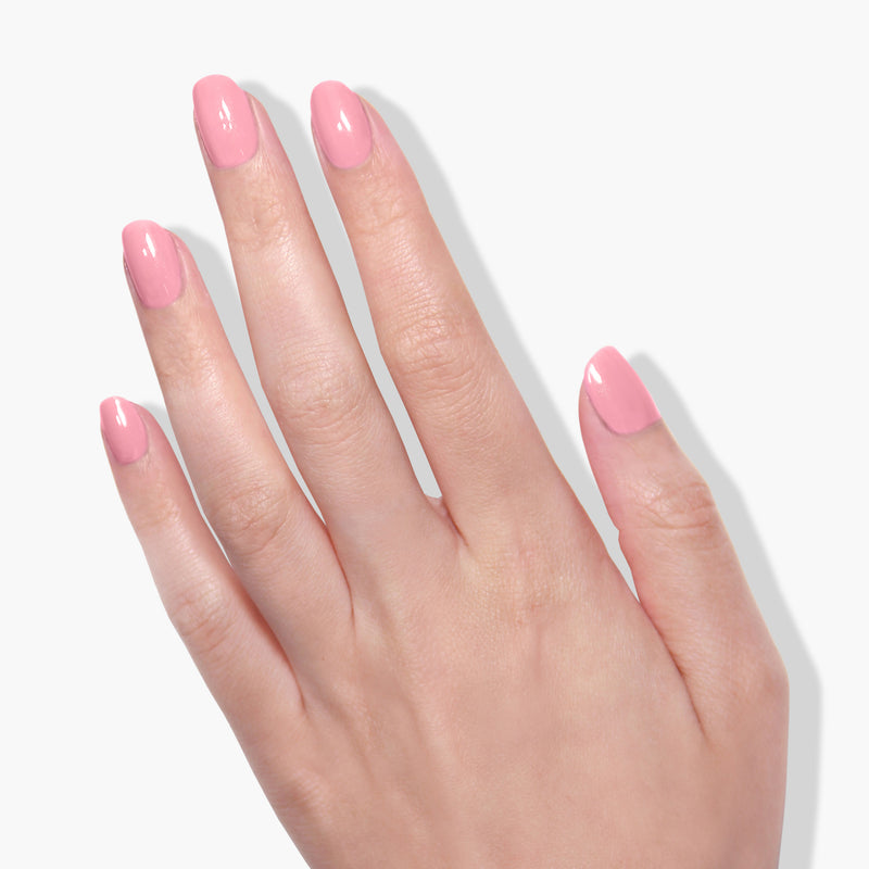 A hand with neatly manicured fingernails painted in LONDONTOWN's Candy Floss UV/LED Gel Color is displayed against a white background, showcasing its high-shine formula.