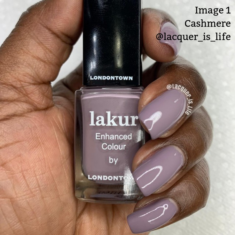 Hand holding a bottle of LONDONTOWN Cashmere nail polish. Nails are painted in the same shade. This vegan, cruelty-free formula ensures a smooth finish. Text overlay reads: "Image 1 Cashmere @lacquer_is_life".