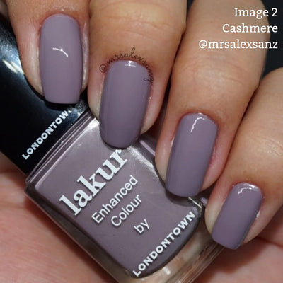 A hand with taupe-colored nail polish holds a bottle of LONDONTOWN's "Cashmere (Professional)," a vegan and cruelty-free nail polish. The Instagram handle "@mrsalexsanz" is visible.