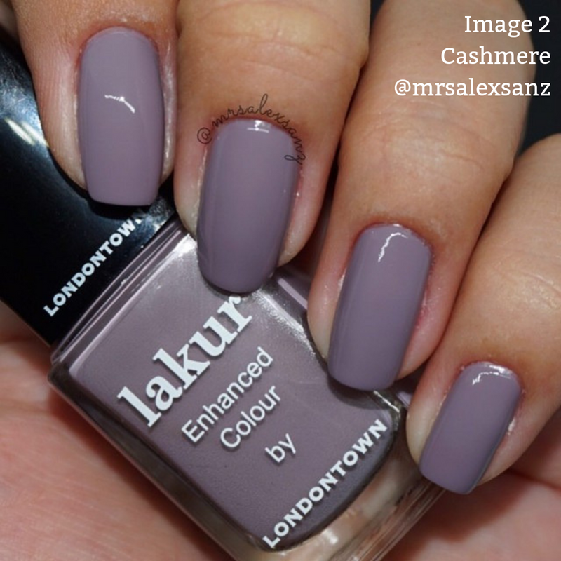 Close-up of a hand with nails painted in a lavender shade, holding a bottle of LONDONTOWN’s Cashmere vegan, cruelty-free nail polish labeled "Enhanced Colour." Text overlays read "Image 2," "Cashmere," and "@mrsalexsanz.
