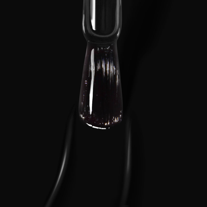 A close-up image of the LONDONTOWN Chim Cher-ee nail polish brush against a jet black crème background, showcasing its visible bristles.