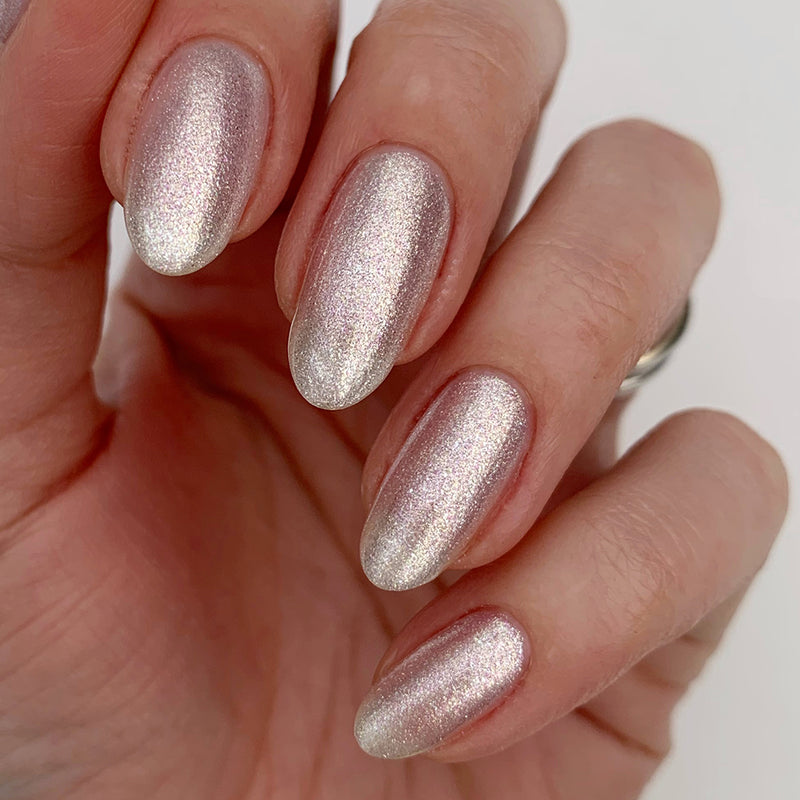 A close-up view of a hand with neatly manicured fingernails painted in the shimmery, light pink shade of LONDONTOWN's Coconut Crush, reminiscent of powdered sugar dusted on a delicate dessert.