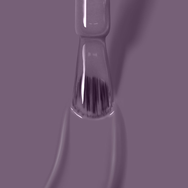 Close-up of LONDONTOWN's Cozy Cashmere nail polish brush with a bristle applicator, coated in a deep purple crème shade, against a matching purple background. Perfect for achieving salon-quality gel manicure results at home.