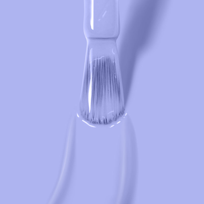 Close-up of a paintbrush applying LONDONTOWN's Dainty Daze, a light periwinkle blue creme paint.