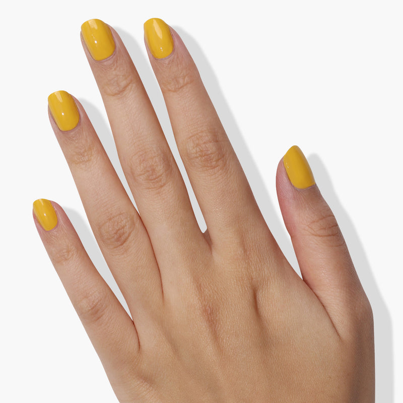 A human hand with cheerful Daisy Chain yellow-painted fingernails from LONDONTOWN is shown against a white background, creating an instant mood boost.
