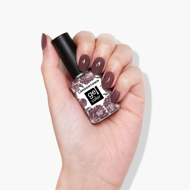 A hand holding a LONDONTOWN Darjeeling gel color nail polish bottle, with the nails painted in a stunning shade of mauve. This gel manicure looks flawless under any UV/LED light.