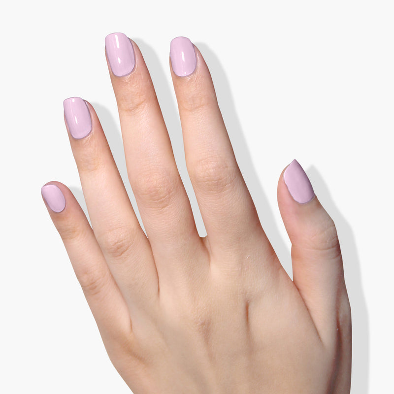 A hand with Dolly Mix, the light pink, vegan cruelty-free nail polish by LONDONTOWN, is shown against a white background.