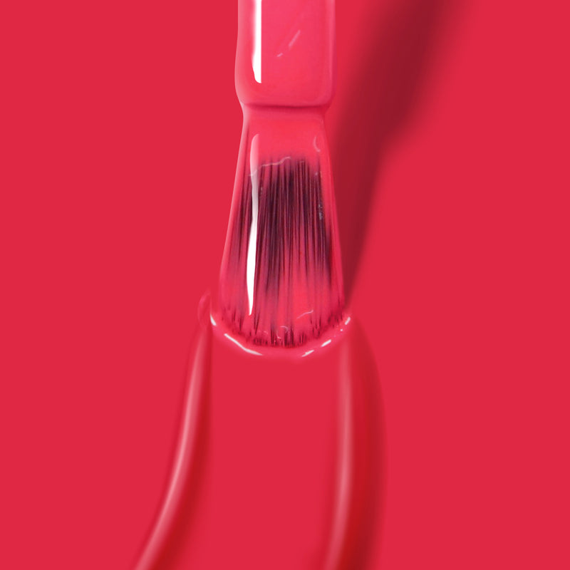 Close-up of a brush applying pink Double the Deck by LONDONTOWN against a solid pink background, showcasing vegan cruelty-free nail polish.