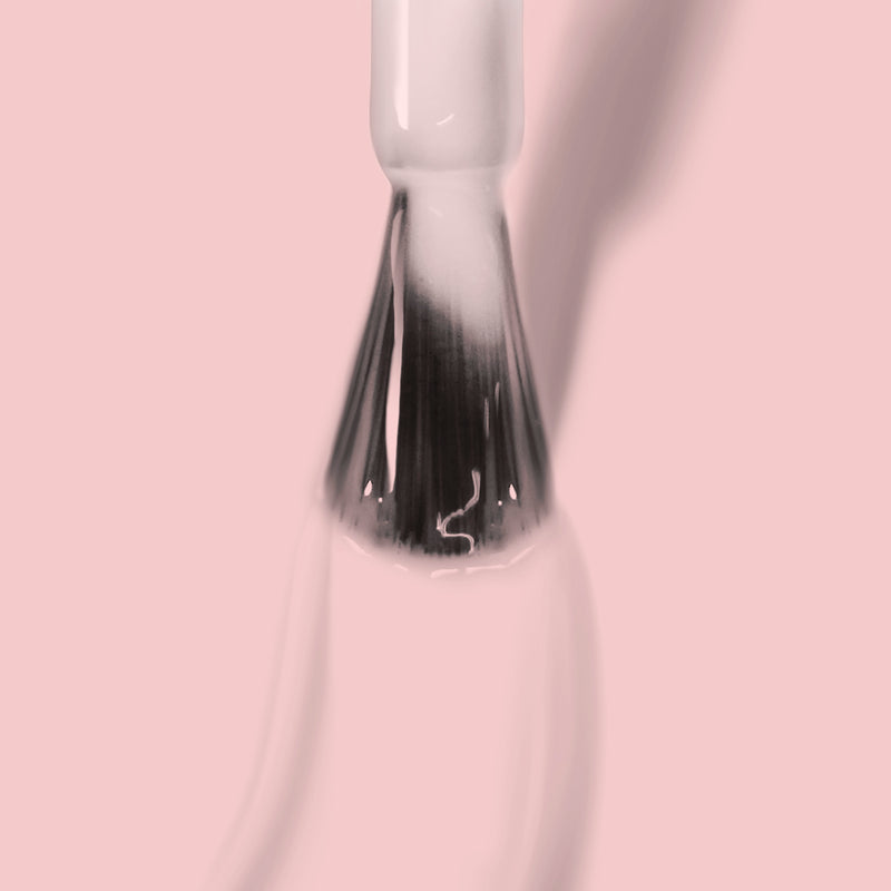 A close-up image of the Dream Scene makeup brush tip by LONDONTOWN, showcasing its white bristles and glossy handle against a light pink background. Shadows of the brush are visible on the surface.