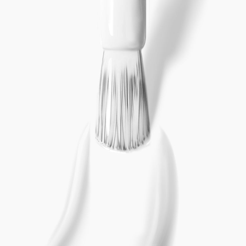 A close-up image of a brush applying a thick coat of LONDONTOWN's Duchess, a pure crème white nail polish, against a white background.