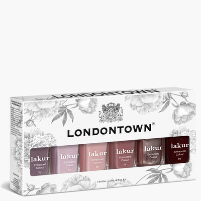 The LONDONTOWN Essential Palette features six Lakur nail polishes in pink, red, and classic neutral shades, all elegantly packaged in a floral-patterned white box.