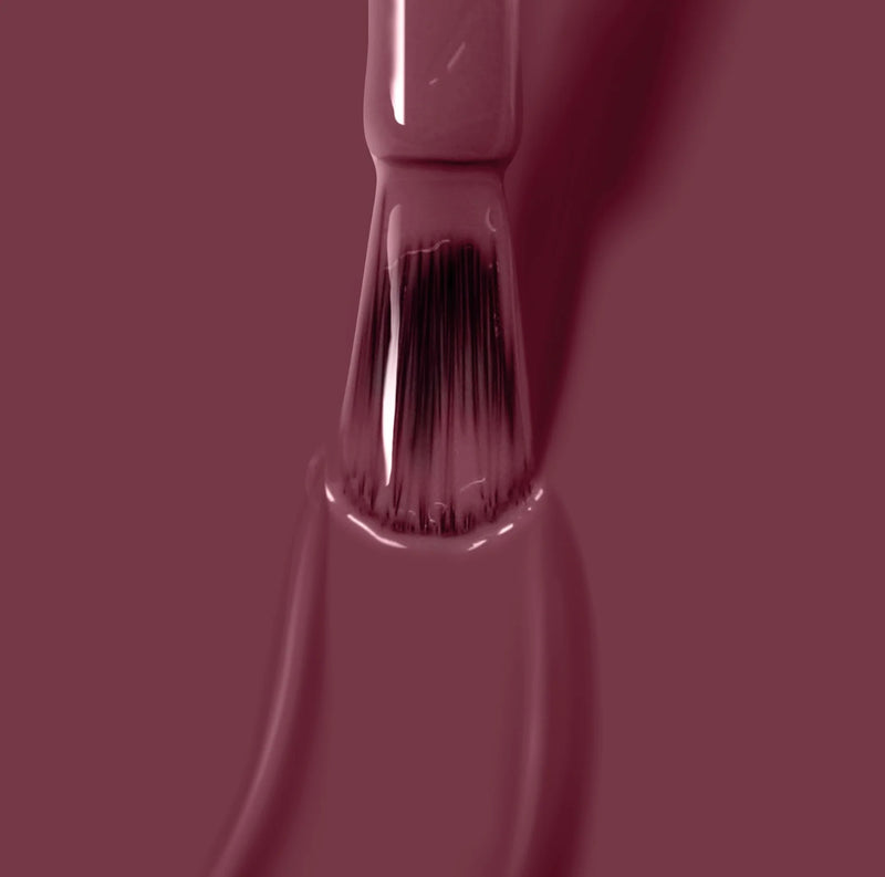 Close-up of a brush applying LONDONTOWN's Fig Jam nail polish.