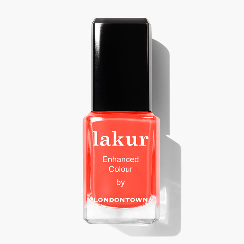 A bottle of Flashback nail polish by LONDONTOWN, featuring a radiant sunset orange shade, with a black cap and white text on the bottle. This vegan, cruelty-free nail polish adds a vibrant touch to your collection.