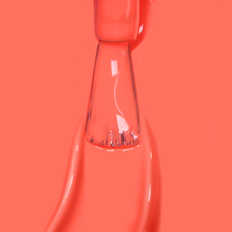 Close-up of a nail polish brush being pulled from a bottle of LONDONTOWN’s Flashback, with radiant sunset orange nail polish dripping and creating smooth, glossy lines around the brush.