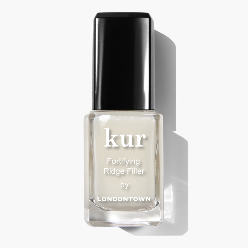 A bottle of LONDONTOWN's Fortifying Ridge Filler nail treatment, featuring a black cap and set against a white background, proudly highlights its vegan and cruelty-free formula.