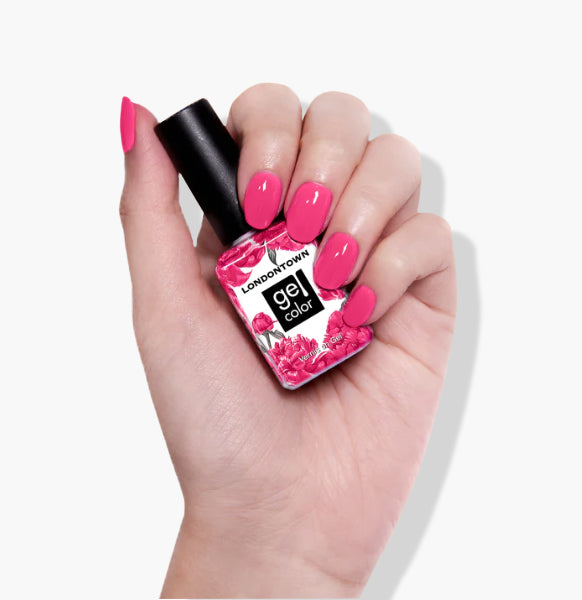 A hand with pink nail polish holds a bottle labeled "Fruit Tella" by LONDONTOWN, featuring a pink floral design. This cruelty-free, vegan formula provides the vibrant allure of UV/LED gel color while maintaining ethical and stylish standards.