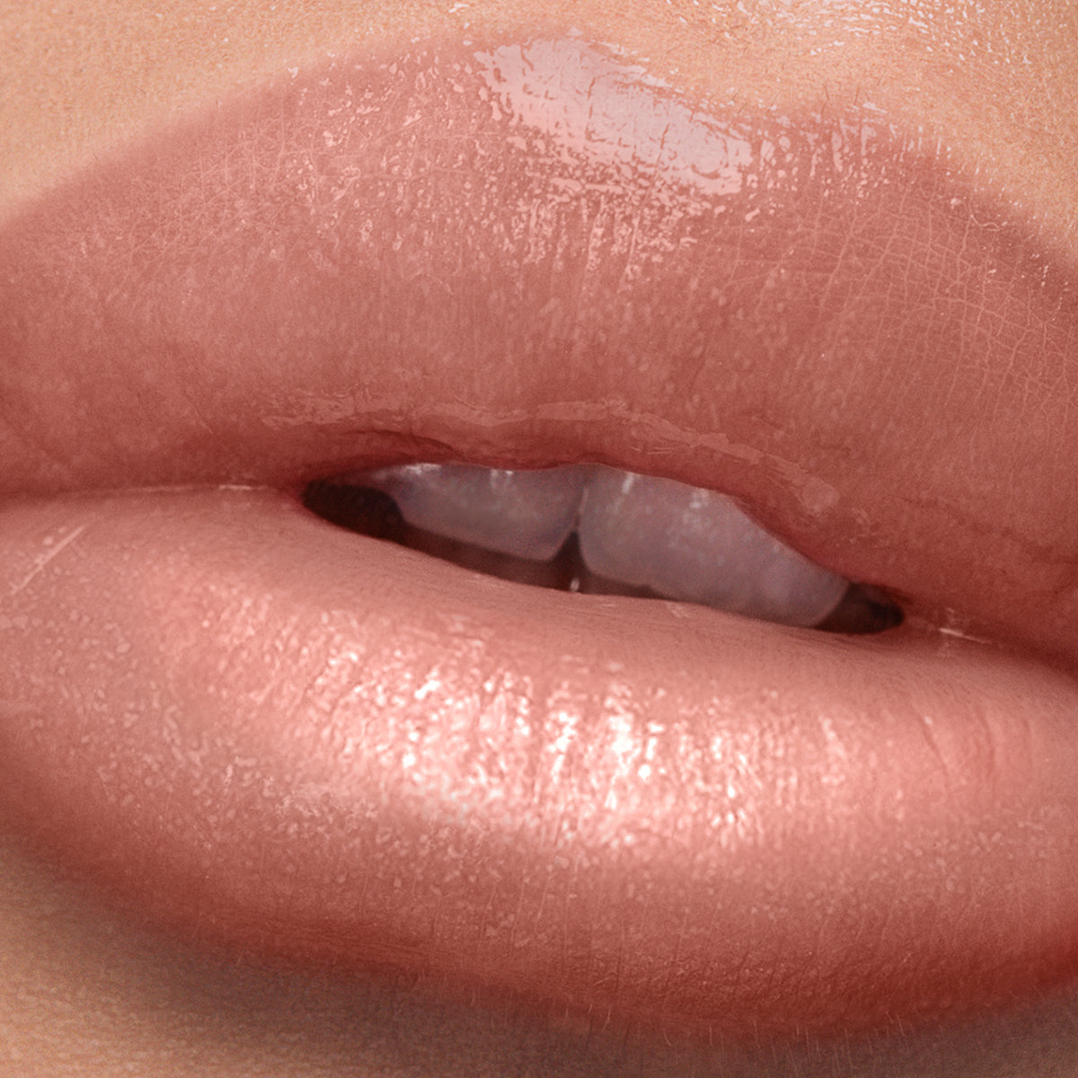 Close-up of glossy, light pink lips slightly parted, revealing upper front teeth with a subtle touch of peachy warmth, enhanced by the Plush Shine Lip Gloss - Gossamer from LONDONTOWN.