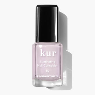 A bottle of LONDONTOWN Pink Illuminating Nail Concealer with a black cap on a white background, offering an instant illuminating brightener with a subtle milky finish.