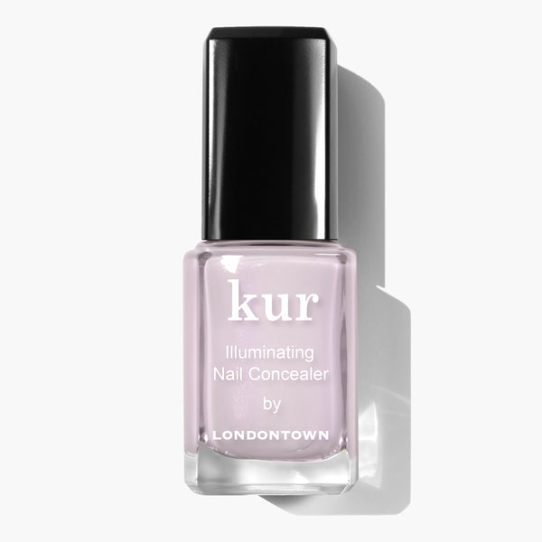 A bottle of LONDONTOWN Pink Illuminating Nail Concealer with a black cap on a white background, offering an instant illuminating brightener with a subtle milky finish.