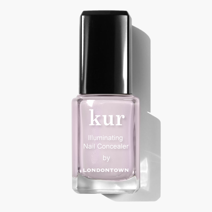 A bottle of LONDONTOWN Pink Illuminating Nail Concealer with a black cap on a white background, offering an instant illuminating brightener with a subtle milky finish.