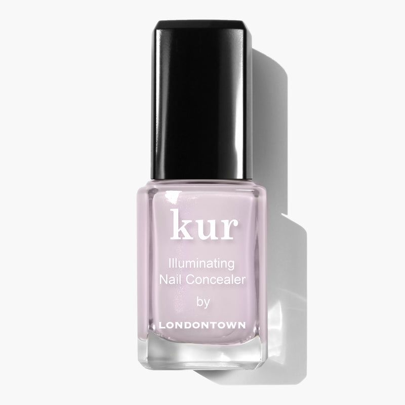 A bottle of LONDONTOWN Pink Illuminating Nail Concealer with a black cap on a white background, offering an instant illuminating brightener with a subtle milky finish.