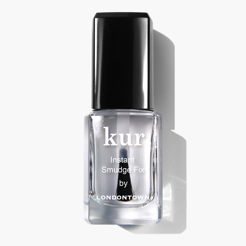 A front-facing view of a clear bottle of LONDONTOWN's Instant Smudge Fix vegan nail polish with a black cap, set against a white background.