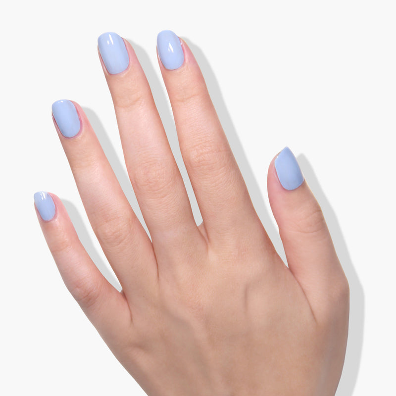 A hand with manicured nails painted in LONDONTOWN's In the Clouds gel color is shown against a plain white background.
