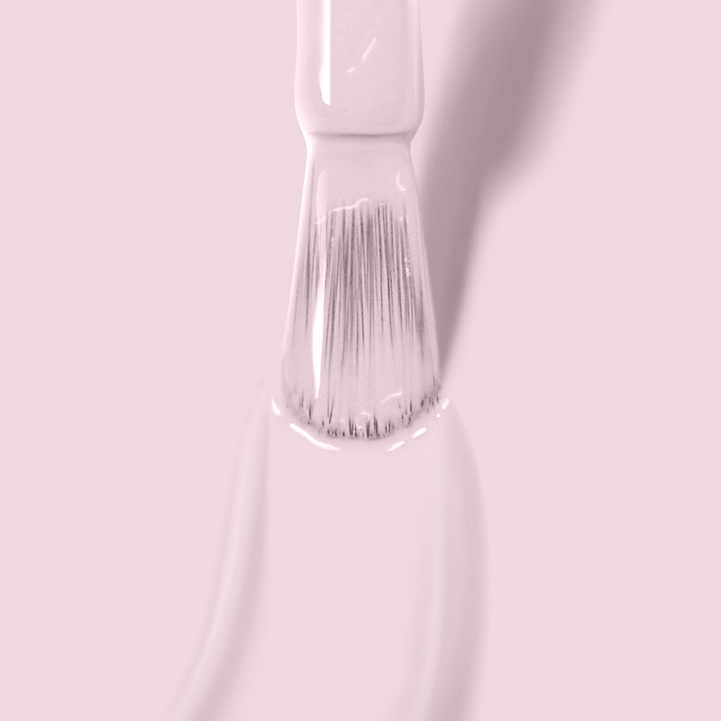 A close-up image of a paintbrush applying the light pink UV/LED Gel Color "Jane Austen" by LONDONTOWN on a surface, showcasing its self-leveling high-shine formula.