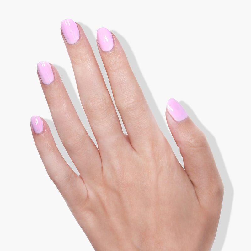 A hand with five fingers is shown against a white background. The nails, coated in LONDONTOWN's refreshing muted pink gel color, Lemonade Pop, gleam softly under the UV/LED light.