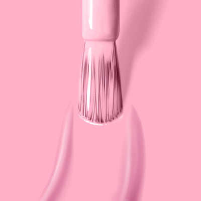 Close-up of a LONDONTOWN Lemonade Pop (Professional) vegan cruelty-free nail polish brush painting a smooth line of muted pink, formaldehyde-free polish on a pink surface.