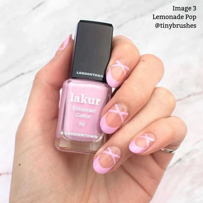 A hand holding a bottle of Lemonade Pop (Professional), a muted pink, vegan, and cruelty-free nail polish from LONDONTOWN.