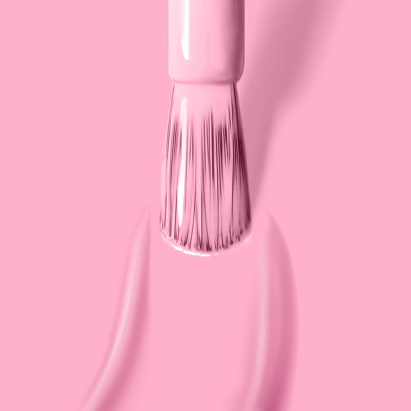 A brush applies the refreshing muted pink shade of LONDONTOWN's Lemonade Pop gel color onto a nail, with the polish spreading smoothly across the surface.