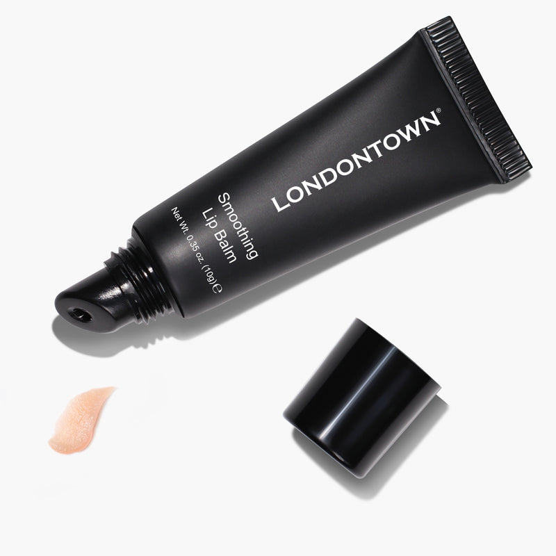 A black tube of LONDONTOWN Smoothing Lip Balm with its cap removed, next to a small amount of the ultra-rich balm squeezed out.