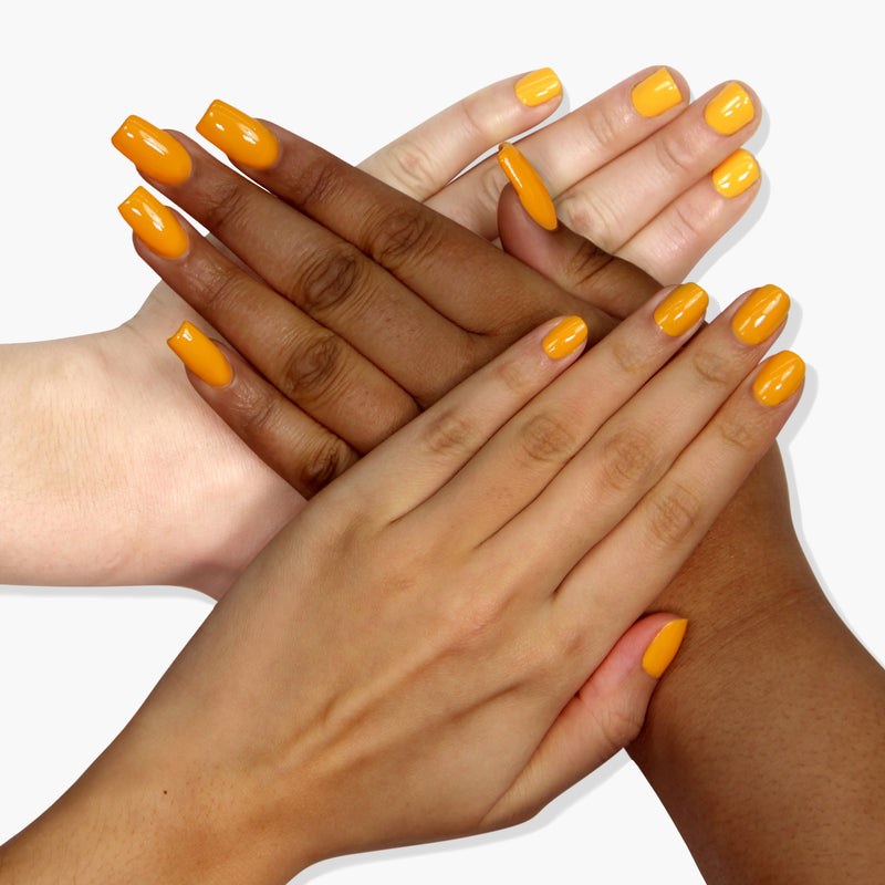 Four hands of different skin tones with yellow painted nails, featuring LONDONTOWN's Mango 16+ free, vegan cruelty-free nail polish, are placed on top of each other against a white background.