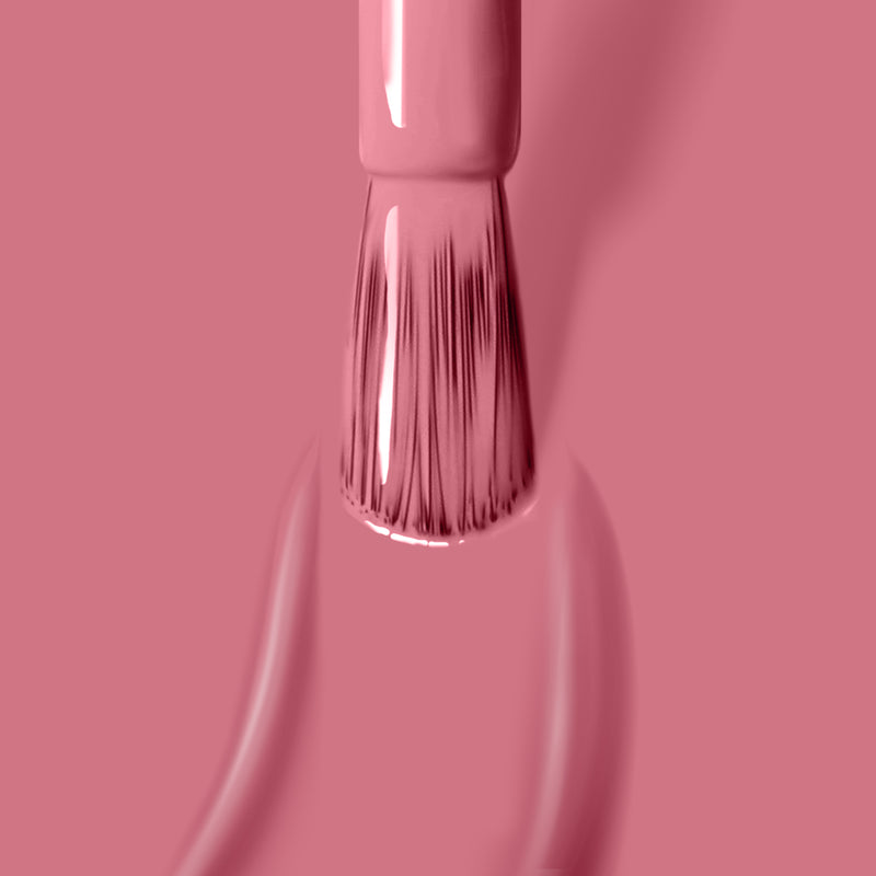 A brush applies a sophisticated Mojave Mauve glossy nail polish by LONDONTOWN on a matching clay rose surface.