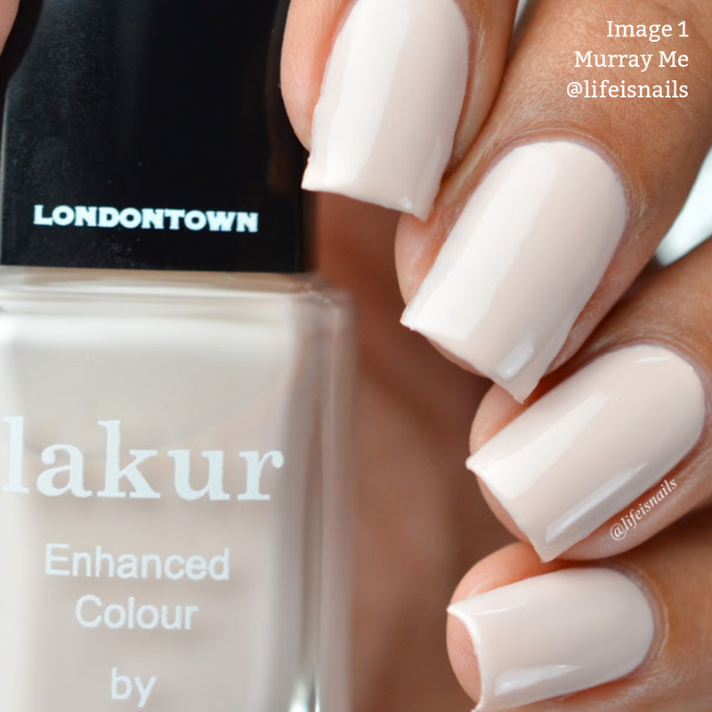 Close-up of a hand holding a bottle of LONDONTOWN Murray Me nail polish in a French vanilla cream shade. The nails are freshly painted with the same color. Text on the image: "Image 1: @lifeisnails. Vegan and cruelty-free.