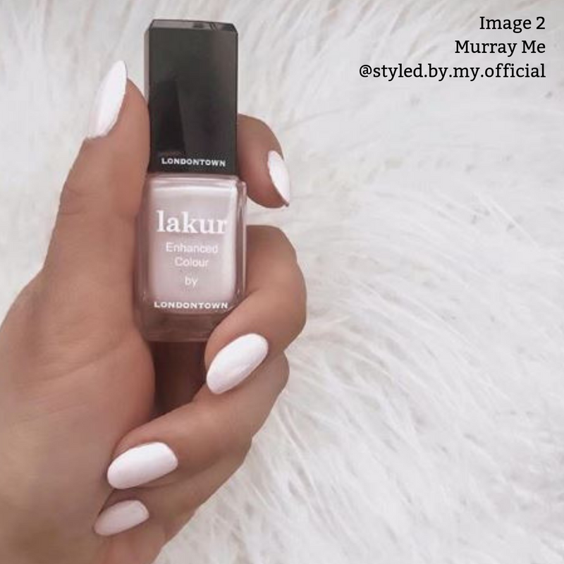 A hand with white nails holds a bottle of LONDONTOWN's Murray Me nail polish in the shade "French Vanilla Cream" labeled "Enhanced Colour." The vegan, cruelty-free formula ensures a perfect finish. The text "Image 2 Murray Me @styled.by.my.official" is in the top right corner.