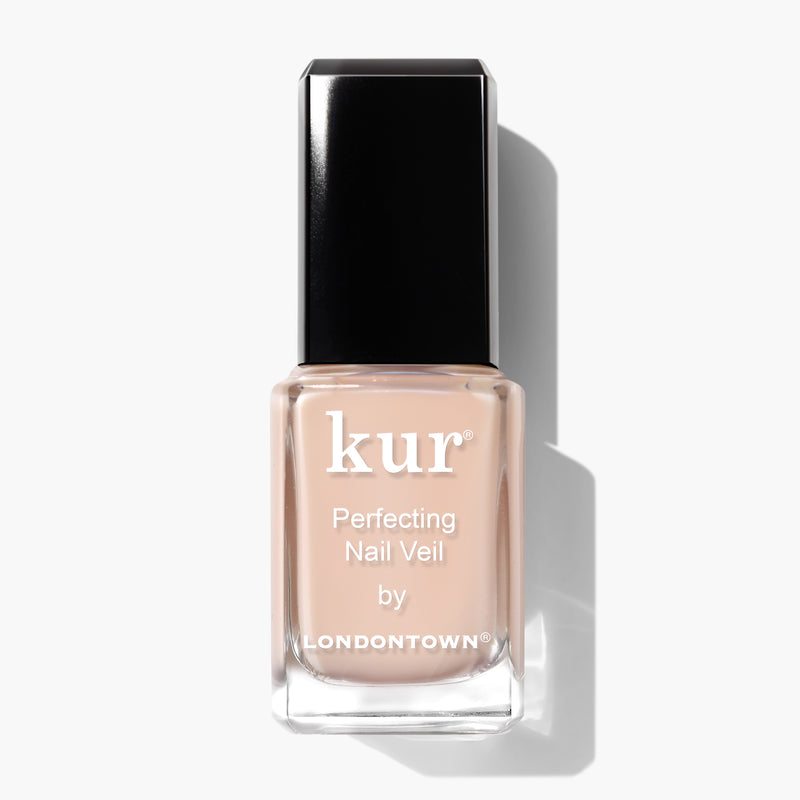 A bottle of LONDONTOWN's Perfecting Nail Veil #1, featuring a square-shaped black cap and a label displaying the product name on a translucent, peach-colored liquid. This power-packed nail veiling solution offers both color and care for your nails.