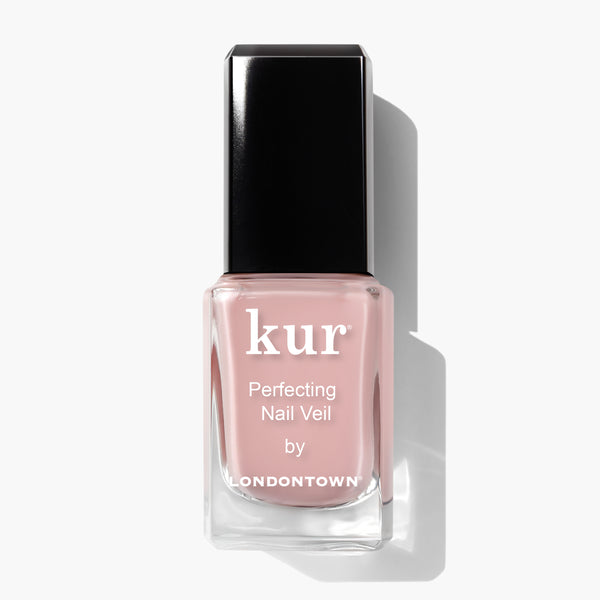 A bottle of LONDONTOWN Perfecting Nail Veil #4 nail polish with a black cap and light pink liquid inside, giving a hint of color, photographed against a white background.
