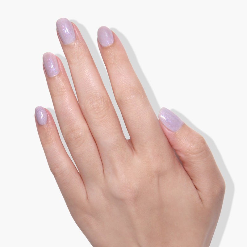 A hand with manicured nails painted in a light shimmering lilac shade against a white background, showcasing the elegance of LONDONTOWN's Opal gel color.