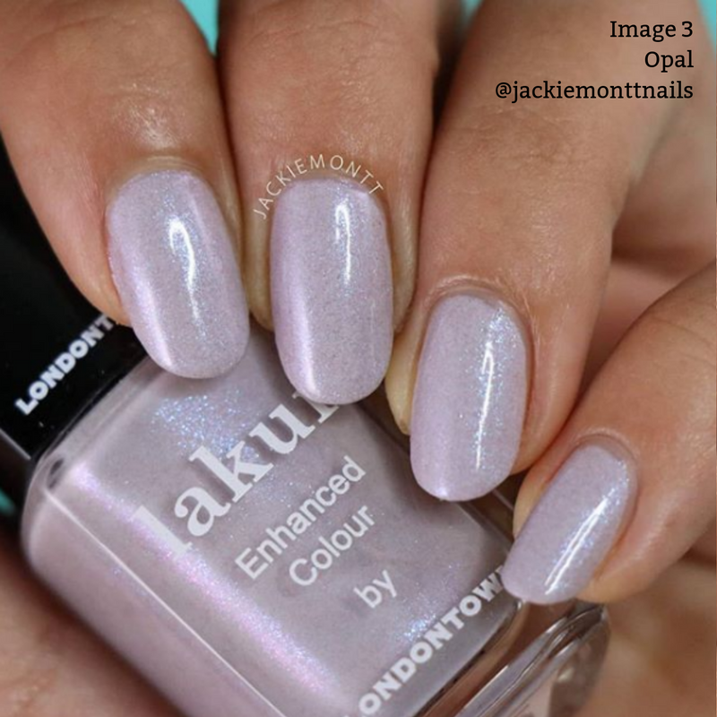Close-up of a hand showcasing nails painted with shimmering lilac polish labeled "Opal" by LONDONTOWN. The bottle of cruelty-free, vegan nail polish is held between the thumb and index finger. Text overlay: "Image 3 Opal @jackiemonttnails".