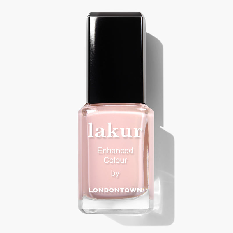 A bottle of LONDONTOWN vegan nail polish named "Peach Pop" with a black cap, displaying the text "lakur Enhanced Colour by LONDONTOWN" on the front. This cruelty-free polish comes in a light pink shade.