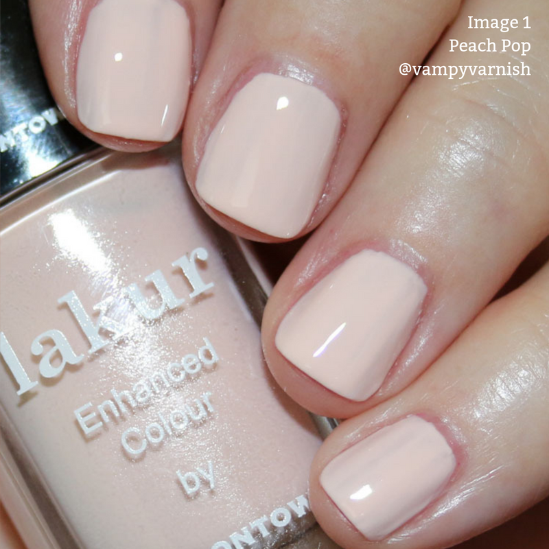 Close-up of nails painted with a peach-colored, Vegan nail polish. The bottle of LONDONTOWN's Cruelty-Free nail polish is labeled "lakur Enhanced Colour: Peach Pop.